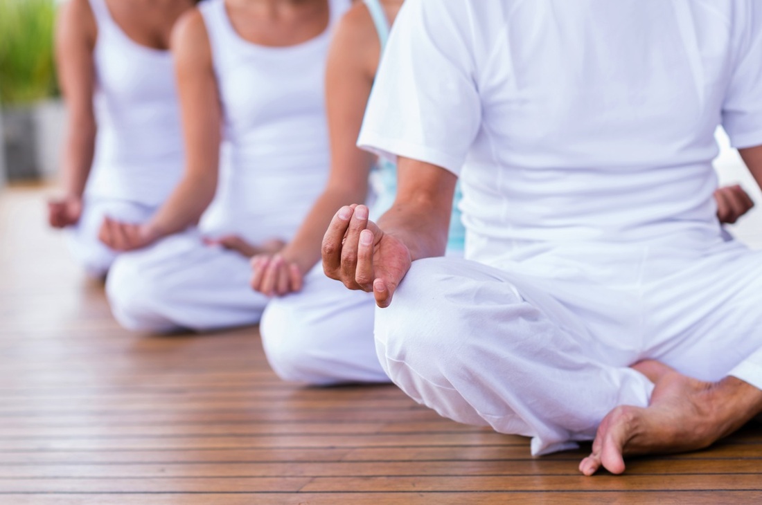 Tres personas en postura de Yoga meditando