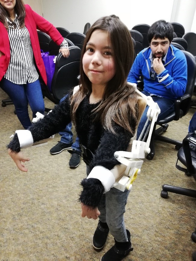 Imagen niña utilizando la Ortesis tipo Exoesqueleto para extremidad superior de color blanco.