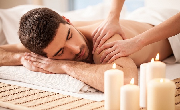 Un hombre tendido en una camilla disfrutando de un masaje de cuerpo completo
